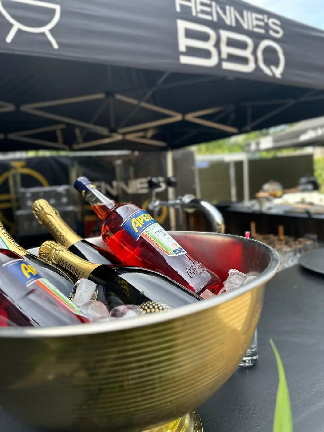 Flessen prosecco en Aperol gekoeld in een grote schaal met ijs